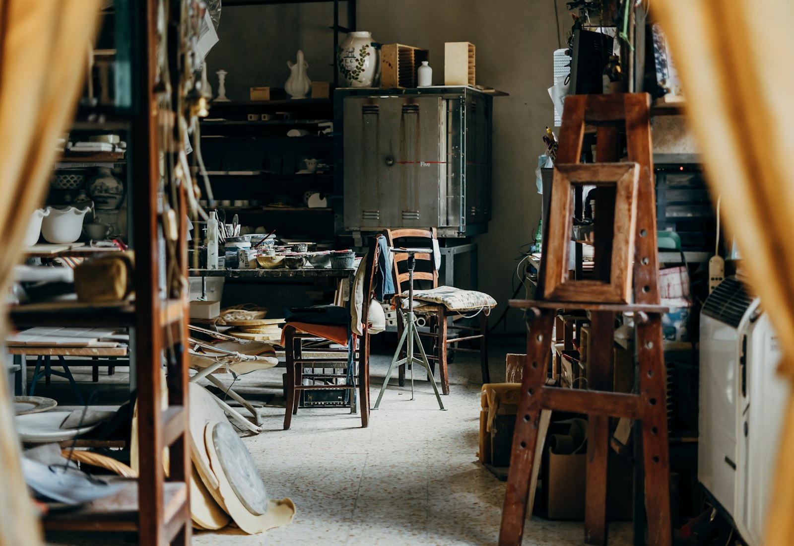 Atelier met houten werktafel, stoelen en keramiek